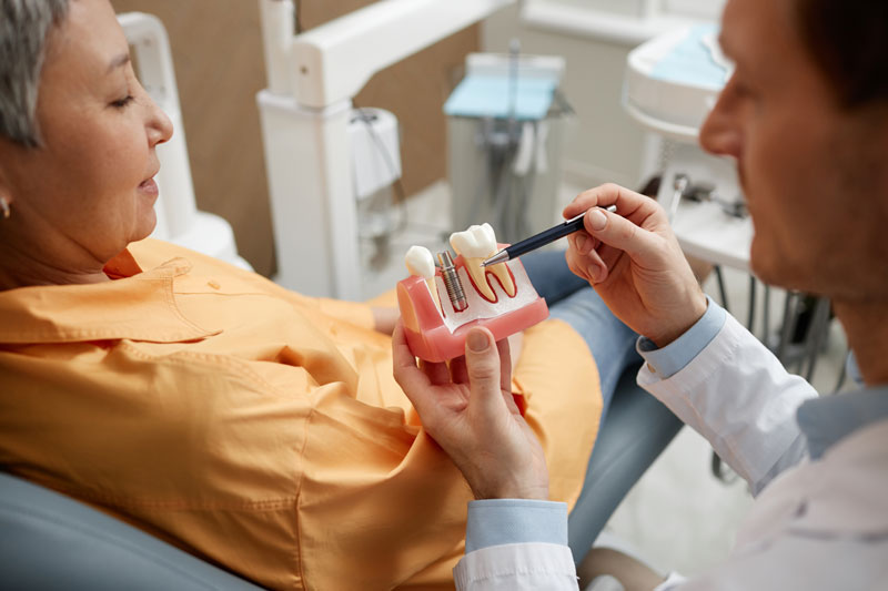 Dental implant consultation with tooth model